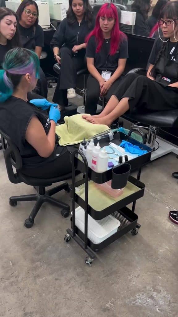LACA class watching a pedicure demonstration by an instructor.